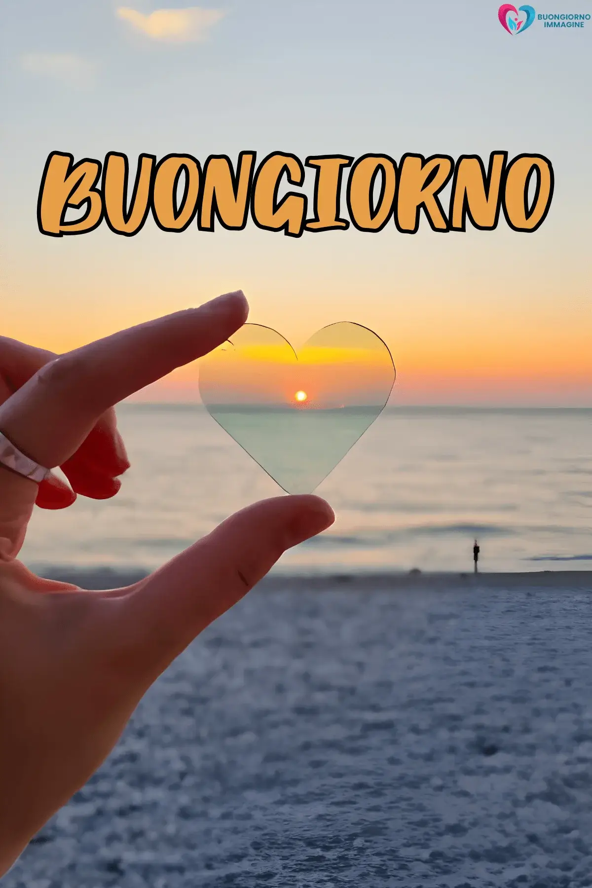 Mano regge cuore trasparente con tramonto sul mare, buongiorno cuore immagini gratis per WhatsApp