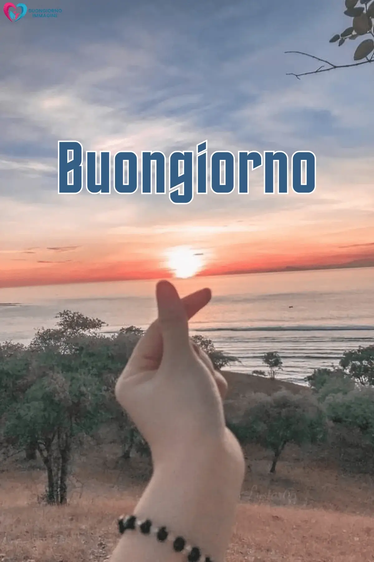 Mano forma cuore al tramonto sul mare, buongiorno con il cuore immagini gratis per WhatsApp
