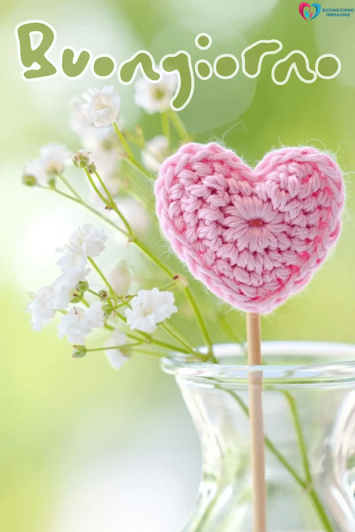 Cuore rosa all'uncinetto su bastoncino in vaso con fiori bianchi, buongiorno cuore immagini gratis per WhatsApp