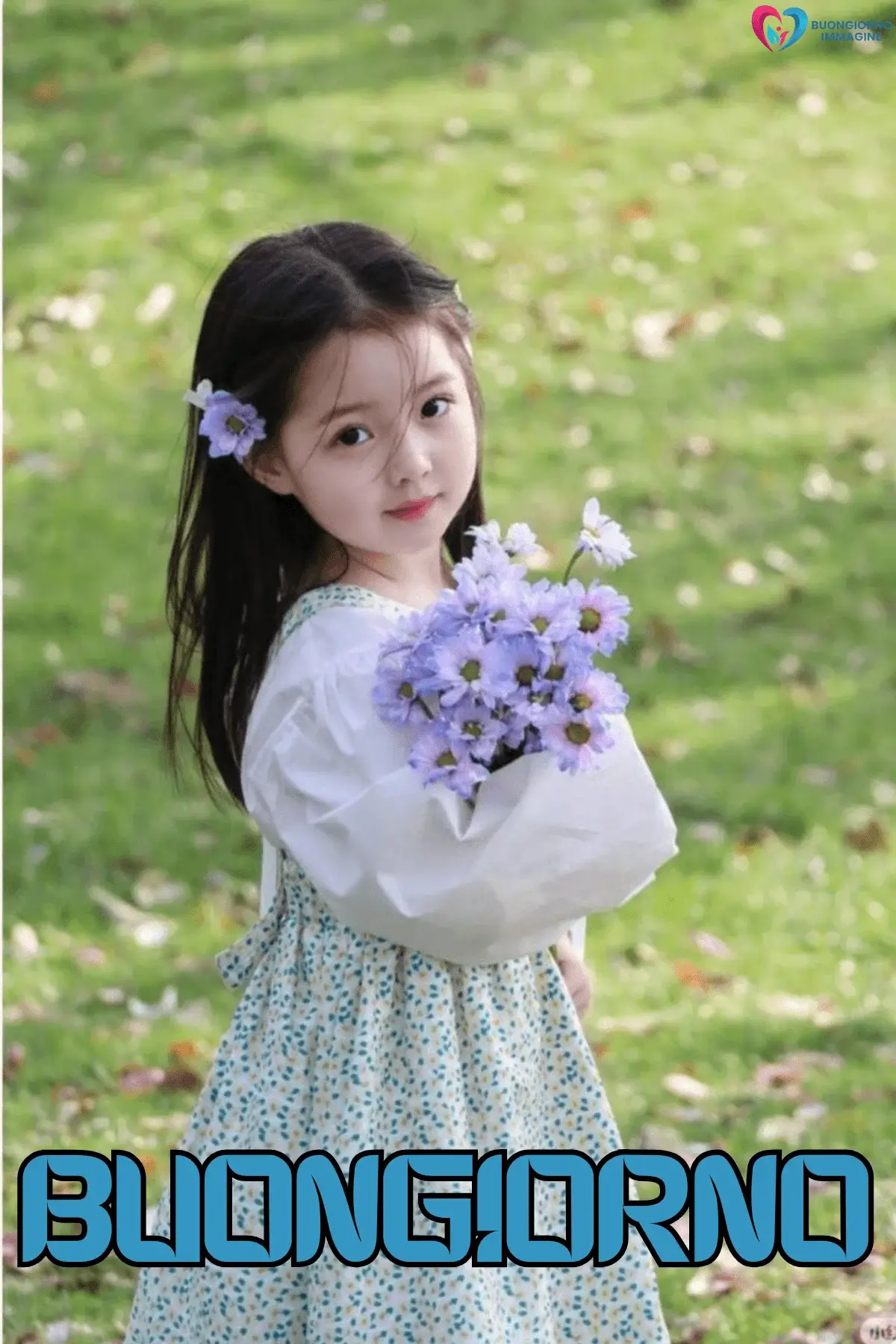 Bambina con fiori viola in un prato verde, buongiorno bambini, immagini gratis per WhatsApp